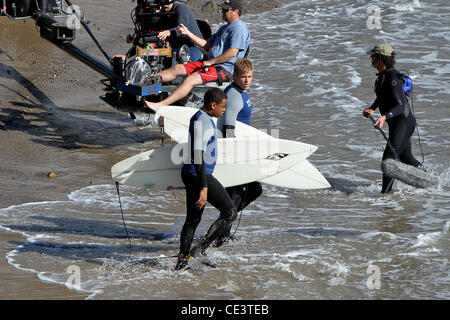 Trevor Donovan and Tristan Wilds Cast members of the television show '90210' film a beach scene with wetsuits and surfboards in Malibu. Los Angeles, California - 22.11.10 Stock Photo