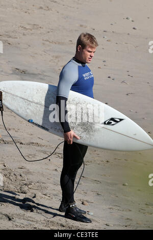 Trevor Donovan Cast members of the television show '90210' film a beach scene with wetsuits and surfboards in Malibu. Los Angeles, California - 22.11.10 Stock Photo