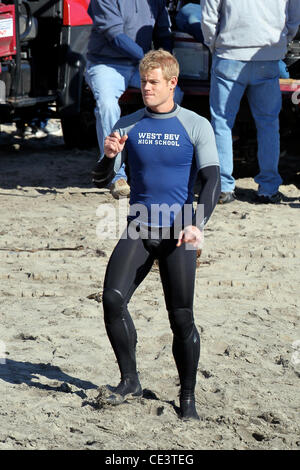 Trevor Donovan Cast members of the television show '90210' film a beach scene with wetsuits and surfboards in Malibu. Los Angeles, California - 22.11.10 Stock Photo