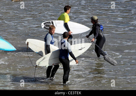 Trevor Donovan and Tristan Wilds Cast members of the television show '90210' film a beach scene with wetsuits and surfboards in Malibu. Los Angeles, California - 22.11.10 Stock Photo