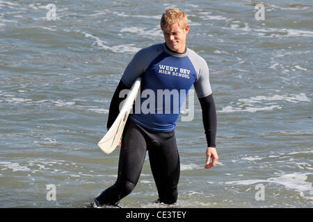 Trevor Donovan Cast members of the television show '90210' film a beach scene with wetsuits and surfboards in Malibu. Los Angeles, California - 22.11.10 Stock Photo