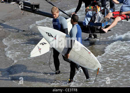 Trevor Donovan and Tristan Wilds Cast members of the television show '90210' film a beach scene with wetsuits and surfboards in Malibu. Los Angeles, California - 22.11.10 Stock Photo