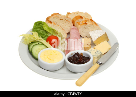 Ploughmans lunch, bread, cheese and ham and salad with butter and pickle on a plate with a knife isolated against white Stock Photo