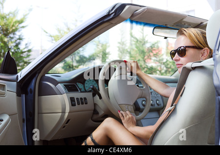 Beautiful blond woman driving her convertible car Stock Photo