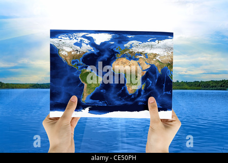 Hand holding map at beauty sunset on river background Stock Photo