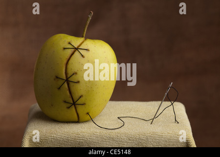 apple manipulated fruit with thread holding it together Stock Photo