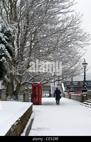 A lone man walking on a pathway beside the River Thames on a cold Winter's Day, London, England Stock Photo