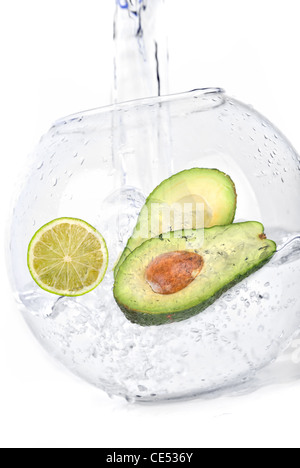 Green limes and avocado in water dropped isolated on a white Stock Photo