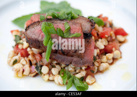 Gourmet dish of sliced roast beef over corn salad Stock Photo