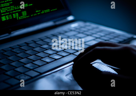 Hacker using laptop. Lots of digits on the computer screen. Stock Photo