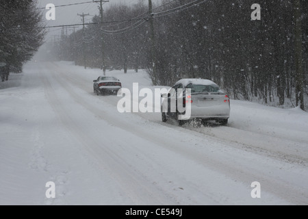 Two cars driving on snow covered roads in Canada Stock Photo