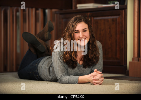 Portrait of young woman laying on floor smiling Stock Photo
