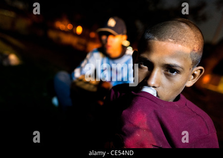 A young Salvadorean boy sniffs glue on the street of San Salvador, El Salvador. Stock Photo