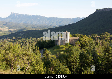 A view from the tiny hilltop village of Gigors of the old Romanesque St Peter’s Church and the mountainous landscape of the Vercors. La Drôme, France. Stock Photo