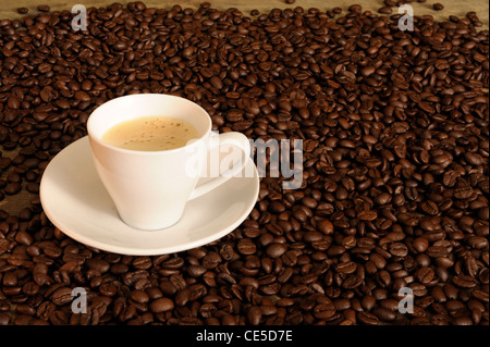 withe cup of coffee between coffee beans Stock Photo