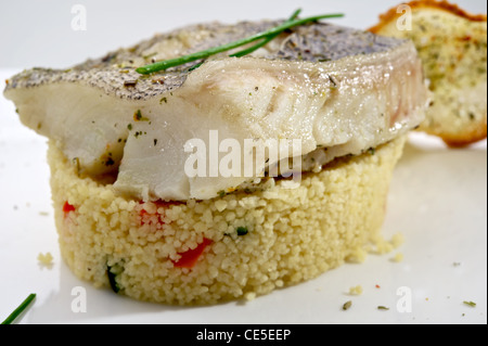 Pike-perch fillet garnished with vegetables and toast, served on white plate Stock Photo