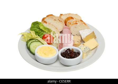 Poughmans lunch, cheeses,ham,bread and salad garnish and pickle on a plate isolated against white Stock Photo