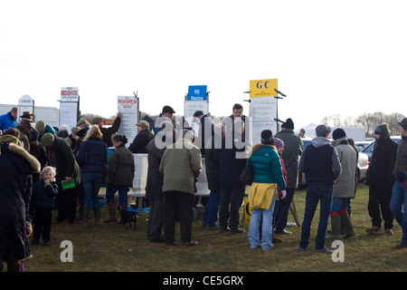 Crowds gathering to place bets with the line of Bookies on stands for the next Horse Race Stock Photo