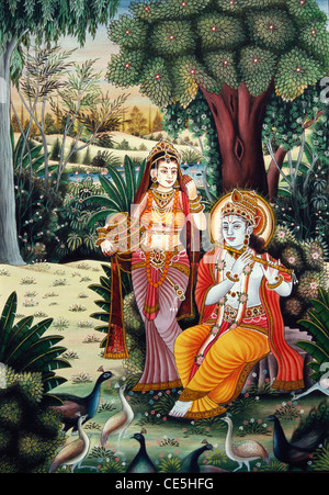 Radha Krishna playing flute in garden with peacocks trees flowers miniature painting on paper Stock Photo
