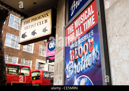 Charing Cross Road London The Phoenix Theatre Theater Artist Club home smash hit show musical Blood Brothers street scene red buses poster posters Stock Photo