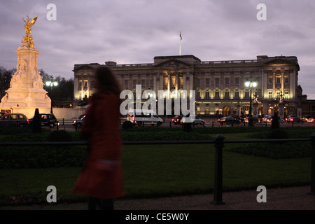 Buckingham Palace at night with a figure walking passed in the foreground Stock Photo