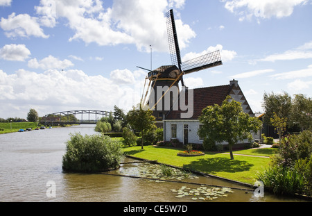 Typical Dutch landscape - windmill, house and bridge at the waterside Stock Photo