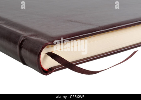 Brown leather book with fabric bookmark closeup, isolated on white Stock Photo