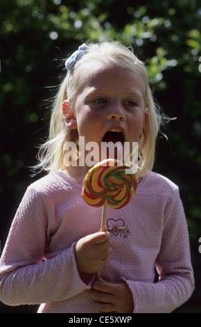 Young girl licking large lollipop. Stock Photo