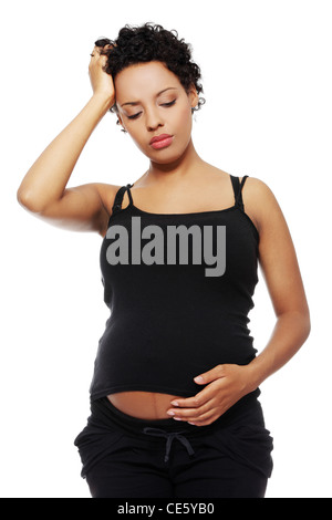 Front view of a pregnant woman holding her hand next to the forehead, having a headache. Isolated on a white background. Stock Photo