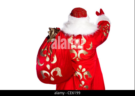 Santa Claus standing up on white background with his bag full of gifts. Photo from behind Stock Photo