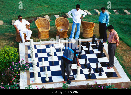 Indian men playing chess on big man size chess board ; Rajasthan ; India ; Asia Stock Photo