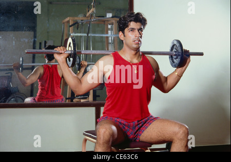 Man doing exercise in gym using weight equipment   MR#139 Stock Photo