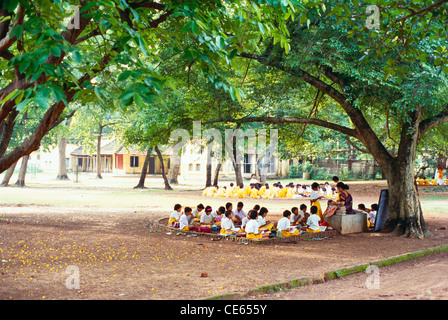 Shanti Niketan ; children studying under trees ; Shantiniketan ; Bolpur city ; Birbhum district ; Calcutta ; Kolkata ; West Bengal ; India ; Asia Stock Photo