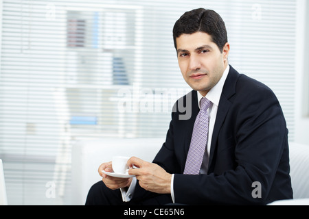 Portrait of attractive businessman with cup looking at camera Stock Photo