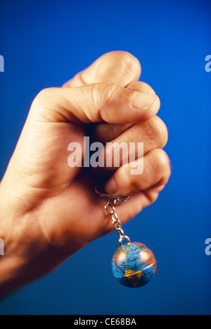Concept ; hand holding globe world earth key chain ; human control power ; man holding world in his hands ; India ; Asia ; MR#201 Stock Photo