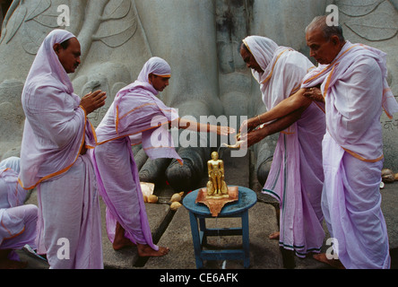 Jain sadhvi pouring water on miniature statue of jain saint Gomateshwara in Shravanbelagola ; Karnataka ; India Stock Photo