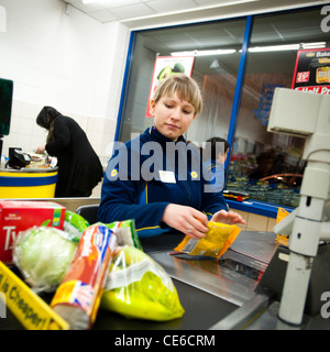 A woman check-out worker at a branch of Lidl discount supermarket, Aberystwyth Wales UK Stock Photo