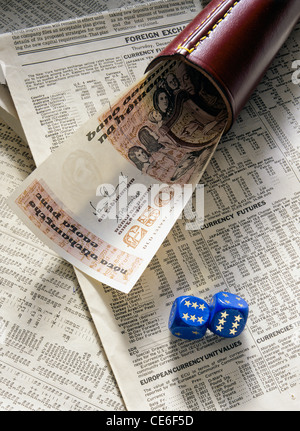 FORMER 50 IRISH POUNDS BANKNOTE WITH 2 EUROPEAN DICE AND SHAKER ON FINANCIAL NEWSPAPER PAGE Stock Photo