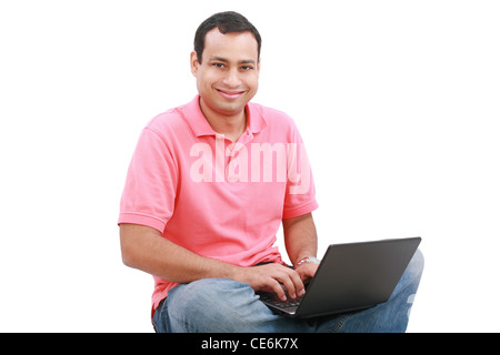 Man sitting on the floor with a laptop - isolated over a white background Stock Photo