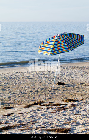 Beach Umbrella and Flip Flops at Sunset Stock Photo