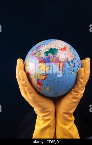 STP 85767 : man wearing rubber gloves holding world globe showing india indian ocean asia chine africa iran saudi arabia Stock Photo