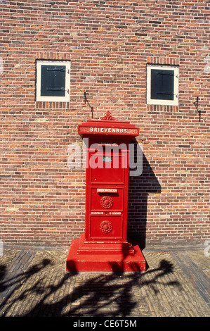 SOA 87840 : red post box on brick wall with two white windows marken dutch village netherlands holland europe Stock Photo
