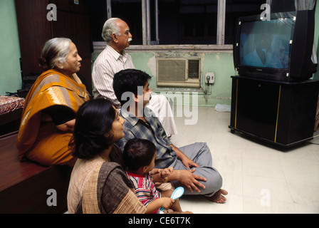 Indian family three generations watching television in home India Stock Photo