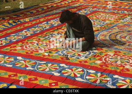 Man cleaning finishing applique patchwork pipli floor covering carpet ; peepli ; Pipili ; Puri ; orissa ; odisha ; india ; asia Stock Photo