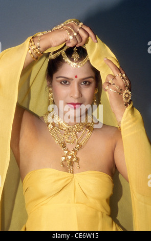 DAC 85239 : woman wearing gold jewellery necklace bangles hand jewelry earring forehead jewelrey india Stock Photo