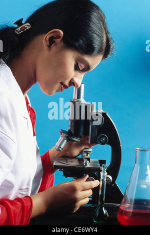 RMM 85320 : woman lab technician looking through microscope doing research india MR#579 Stock Photo