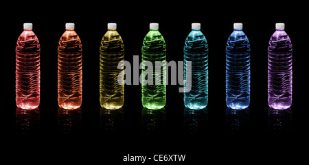 Seven bottles of drinking water colors of the rainbow on a black background Stock Photo