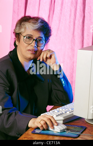 HMA 84147 : South Asian Indian old senior women executive lady grey hair glasses sitting working computer mouse keyboard MR#268 Stock Photo