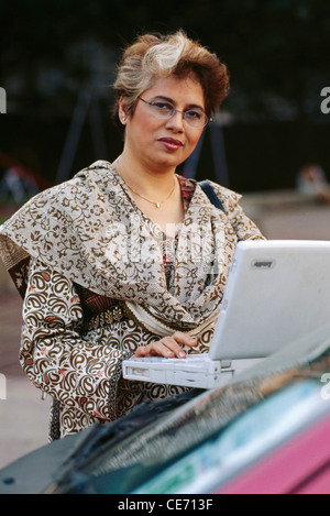 HMA 84148 : South Asian Indian old senior women executive lady grey hair glasses operating working laptop MR#268 Stock Photo