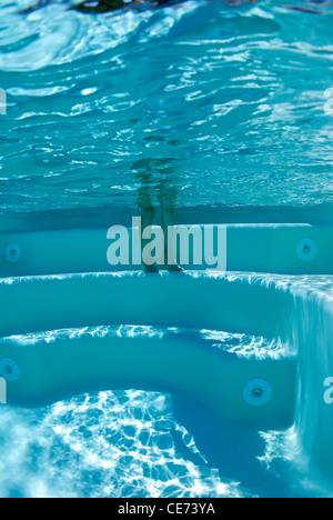 Girl's legs and feet in swimming pool, underwater view Stock Photo
